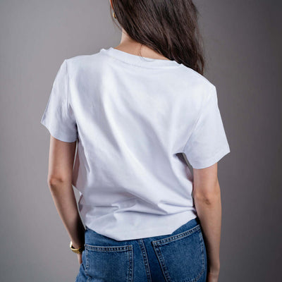 Női Kratom World póló „Me? On Kratom? Never.” motívummal – eredeti merch kratomkedvelők és a Kratom World márka rajongói számára, stílusos streetwear design hangsúlyos nyomattal, kényelmes póló mindennapi viseletre, ideális városba, eseményekre vagy gyűjtői darabként a kratom közösség számára, hátoldal